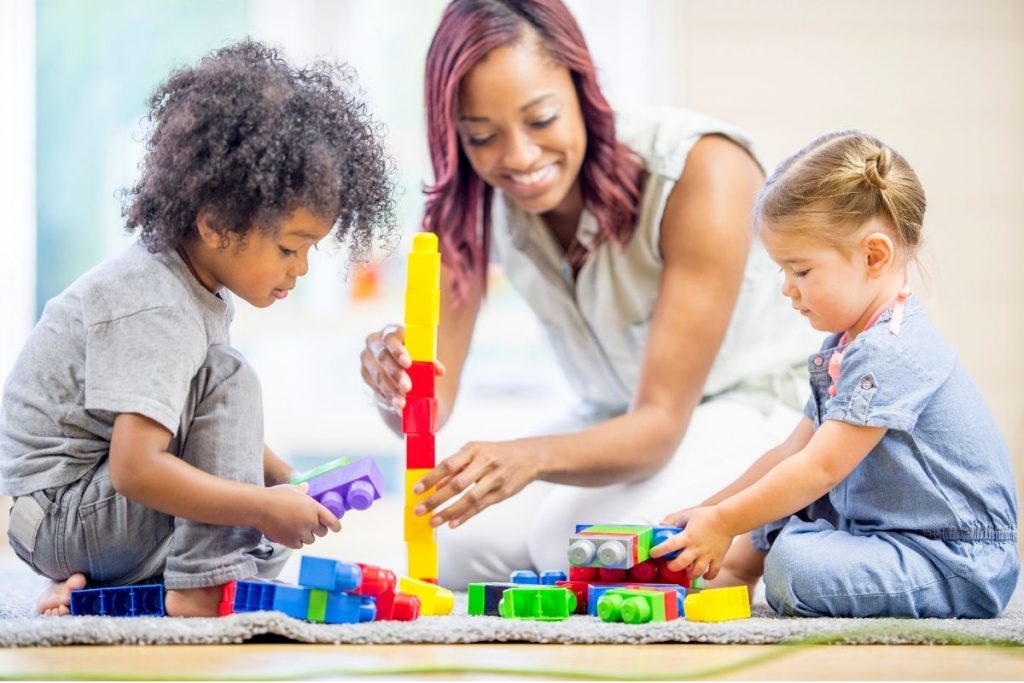 teacher and preschool children playing with blocks